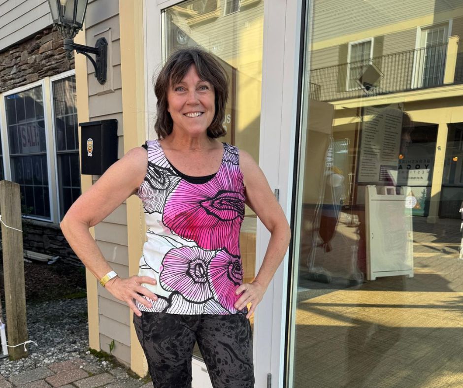Close-up of the Flora Pink Zentangle tank featuring bold hand-drawn flowers, hanging outside a studio door in natural light, highlighting the vibrant print and breathable fabric.